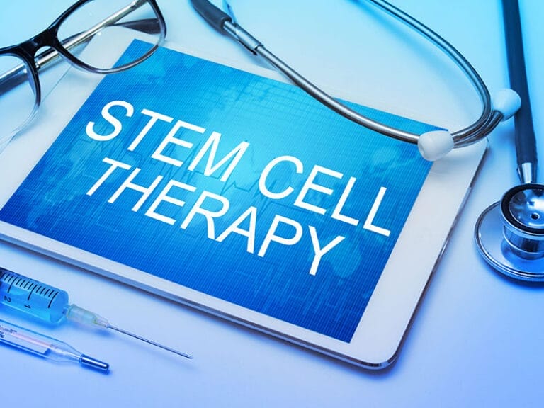 Tablet displaying "Stem Cell Therapy" with a stethoscope, glasses, and syringe nearby.